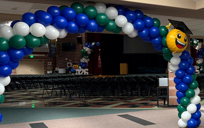 Blue, white and green balloon arch framing a large event venue
