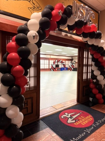 Close-up view of a red, white and black Blown Away balloon arch